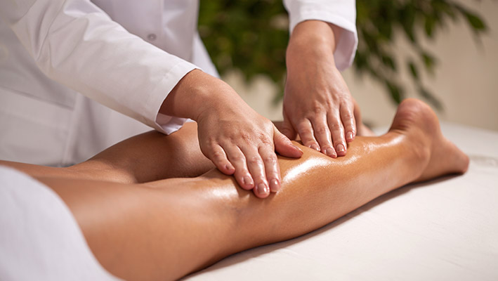 técnica de fisioterapia a massager perna de uma paciente